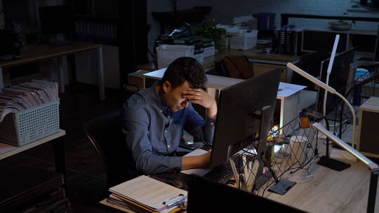 在办公室加班的商务男士