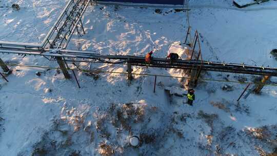 工人在雪场修理车间附近的外管道