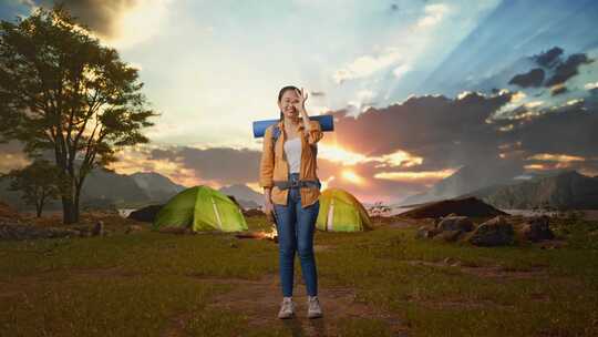 亚洲女性徒步旅行者在帐篷营地湖边用手指遮