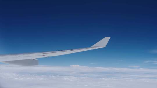 飞机上看窗外机翼划过蓝天白云