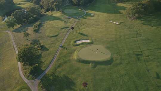 用高尔夫球杆击球的绿色高尔夫球场鸟瞰图视频素材模板下载