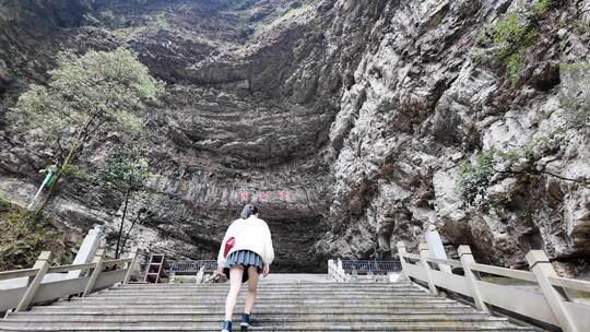 女子走在通往山洞的石阶上