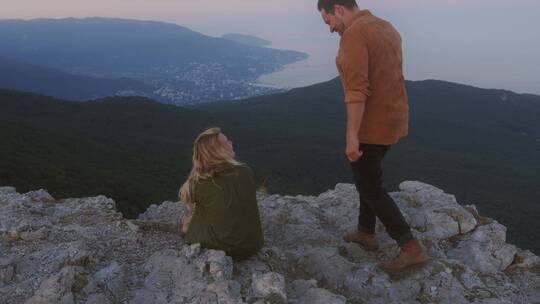 情侣坐在悬崖边上看风景视频素材模板下载