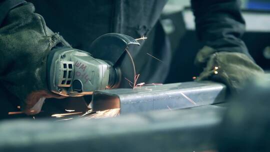 焊接技师正在用锯子切割铁梁