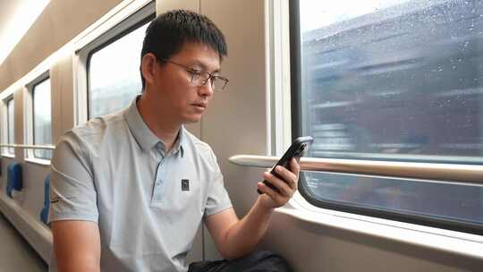 男子在卧铺火车过道上使用手机