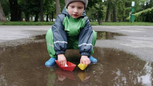 穿雨靴的孩子在公园玩耍