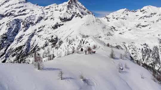 一组滑雪旅游在皮肤上坡排成一行。在大山里滑雪旅游