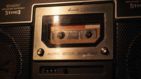 柔和闪烁烛光下老式磁带录音机中的盒式磁带播放
