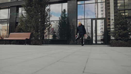 一名霹雳舞者在被现代玻璃建筑包围的城市街