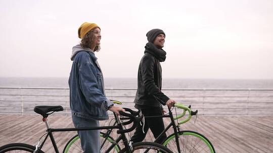 情侣推着自行车在海边散步