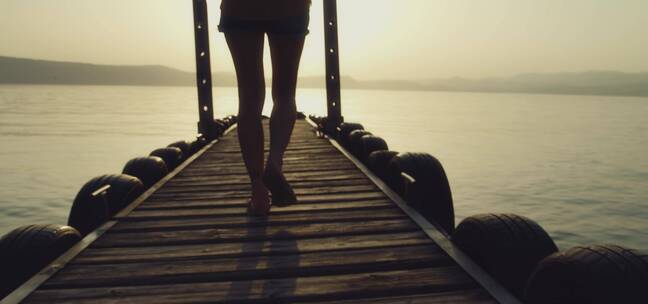 在海边小桥上散步的女孩