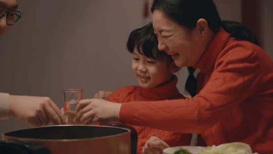 春节：一家人过节团聚吃火锅，举杯的画面视频素材模板下载