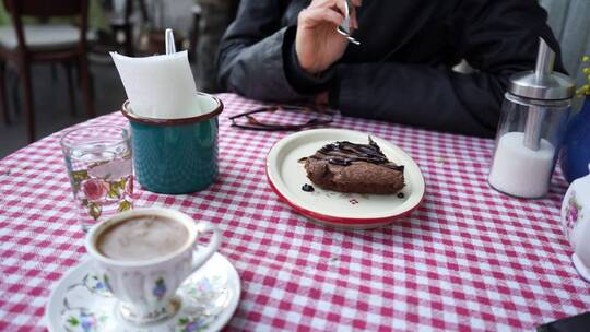吃巧克力蛋糕配土耳其咖啡的女人