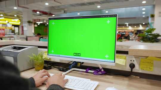 男子在绿色屏幕的电脑前办公