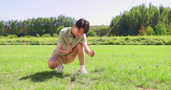 一个年轻男人在露营地搭建帐篷