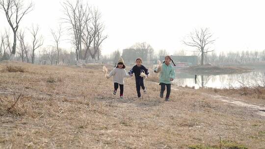 冬季在公园湖边游玩的三个中国女孩