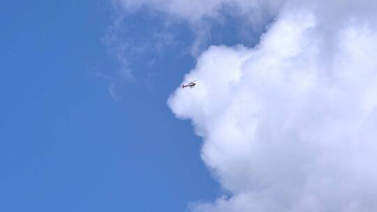 直升机在蓝天白云飞行