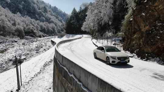 奔驰小轿车在雪地公路行驶旅行航拍雪景雾凇