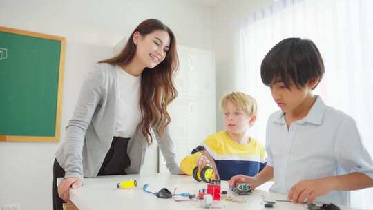 可爱的学生在小学教室里和老师一起学习。