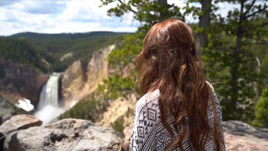 女人站在山上看瀑布