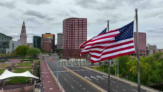 哈特福德康涅狄格州的天际线。空中飘扬的美国国旗。康涅狄格河上的桥。视频素材模板下载