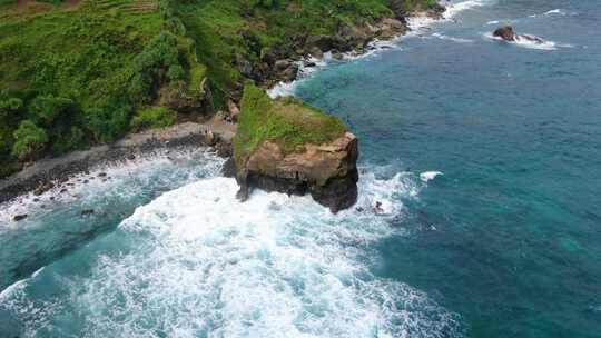 印度尼西亚开布门门甘蒂海滩岩石悬崖上的海浪。空中自上而下盘旋