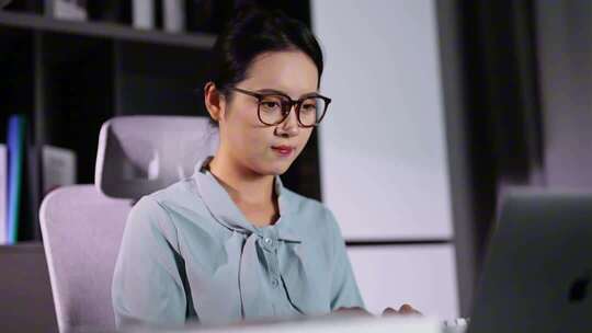 办公室内女性坐着工作画面