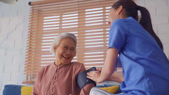 亚洲护理医生检查老年患者使用血压计。