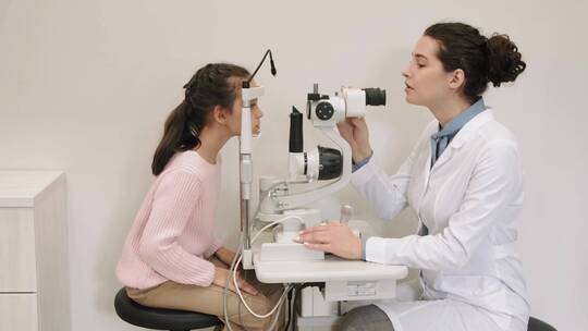 现代诊所女医生的眼科医生定期检查小女孩