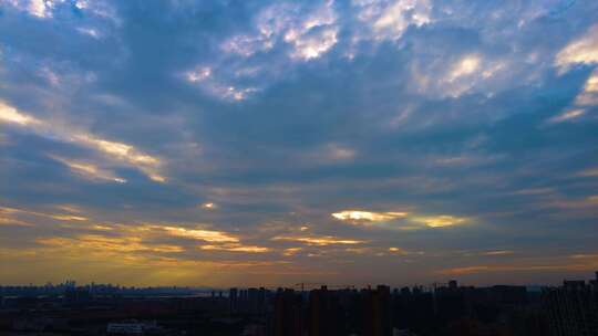城市傍晚阳光穿过云层延时摄影