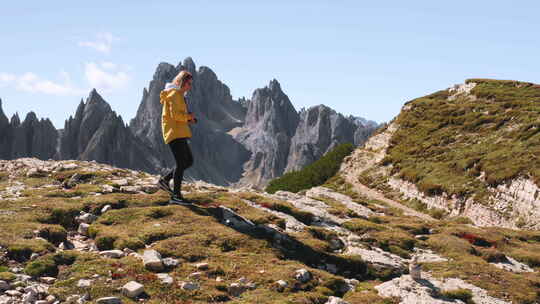 女人在意大利阿尔卑斯山对抗落基山峰散步