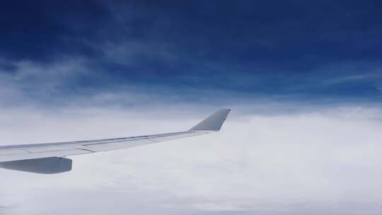 飞机上看窗外机翼划过蓝天白云