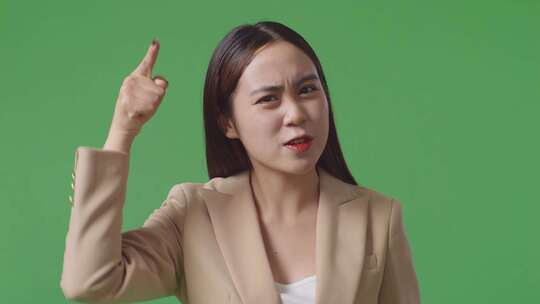 愤怒的亚洲女商人站在工作室的绿屏上责骂的特写镜头