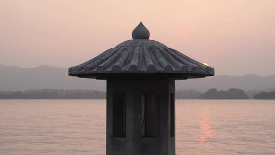 夕阳下西湖上的水泥灯塔