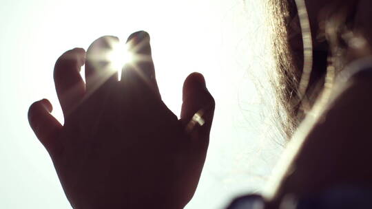 阳光照在一个女人的手上视频素材模板下载