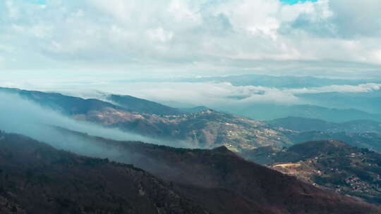 雾蒙蒙的山景，阳光明媚的山谷和云层覆盖的