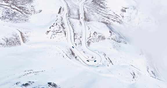 汽车行驶在冬季白雪覆盖的夹金山蜿蜒盘山路