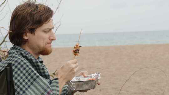 在海边的海滩上野餐，多云。一个穿着格子格
