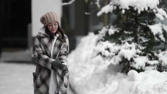 白天在冬城散步年轻女子手上戴着手套感到寒冷