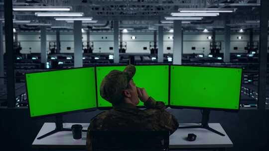 疲惫的亚洲军事打哈欠，而工作模拟多台电脑