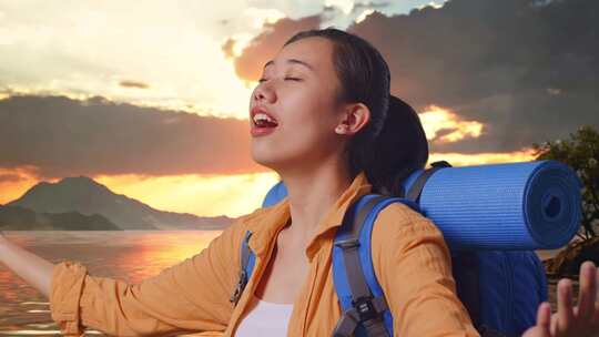 亚洲女性徒步旅行者在湖边张开手臂的特写侧