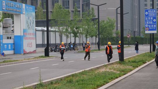 工地门口过马路的建筑工人