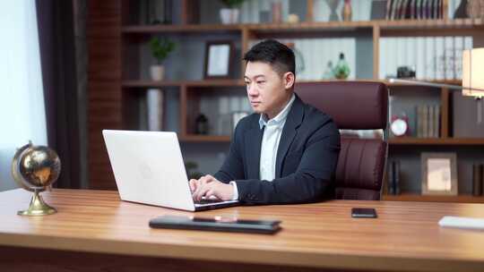 亚洲商人律师在现代办公室使用笔记本电脑工