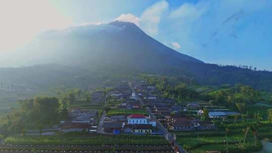 默拉皮火山隐藏在阳光背后，下面是小村庄，