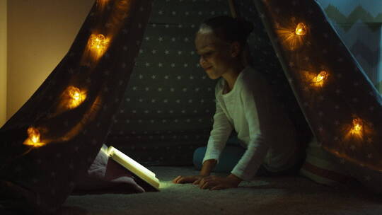 儿童在帐篷里阅读书籍视频素材模板下载
