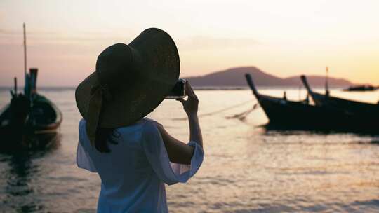 女人海边用手机拍摄夕阳视频素材模板下载