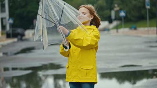 之后，一个穿着黄色夹克打着雨伞在公园散步