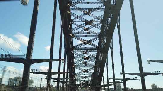 以悉尼天际线为背景，穿过悉尼海港大桥向北郊行驶
