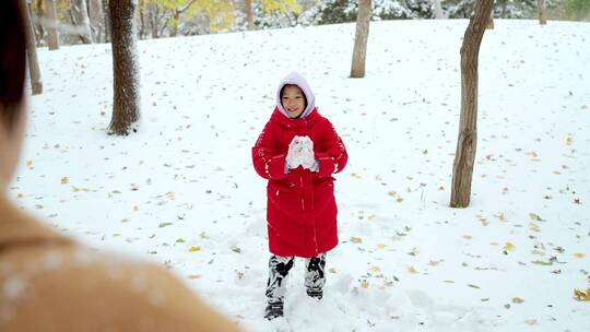 在公园里打雪仗的一对中国母女