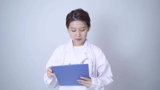 年轻女医生手持病历本书写记录视频素材模板下载